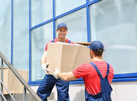 Removal company team loading boxes into a van