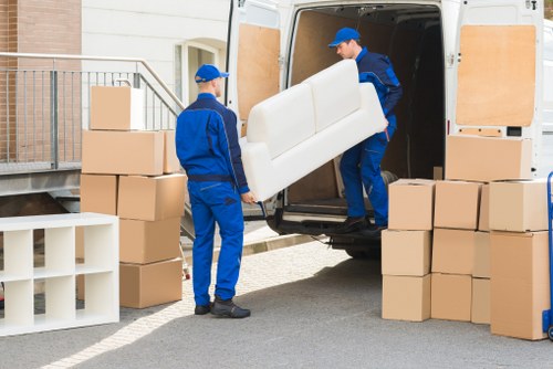 Furniture removal team handling a large sofa in Bromley