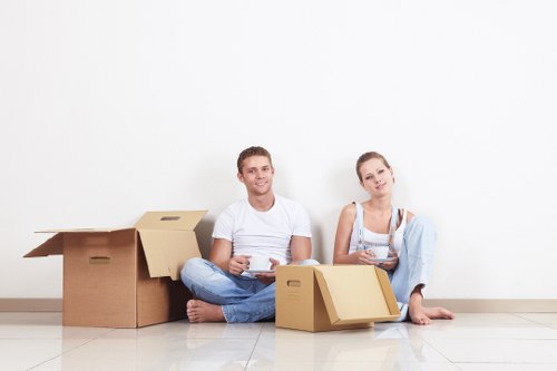 Professional movers carrying furniture through a Bromley flat or home entrance