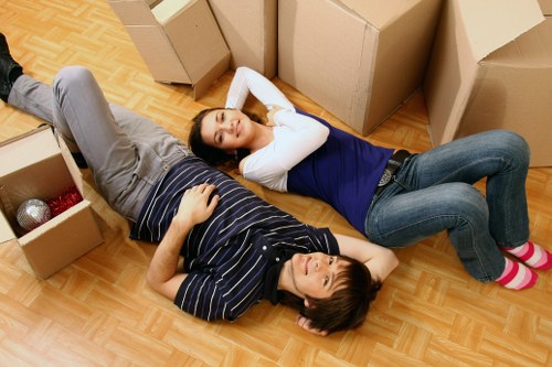Local movers carrying furniture through a Bromley property