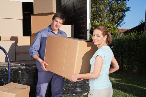 Professional movers carrying furniture through a narrow staircase during a flat removal